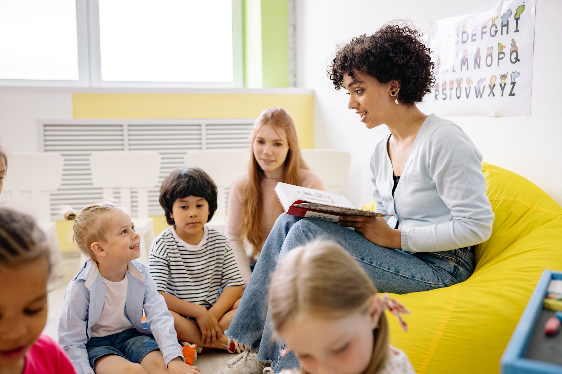 An educator sharing a book with young students